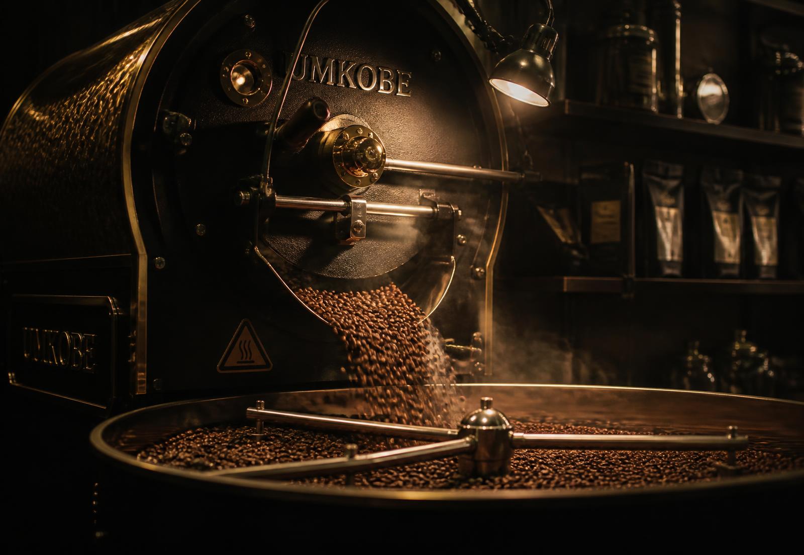 Drum roaster releasing freshly roasted beans into a cooling tray
